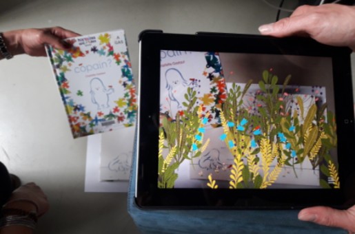 Photographie d'une tablette montrant les images produites par un album en réalité augmentée